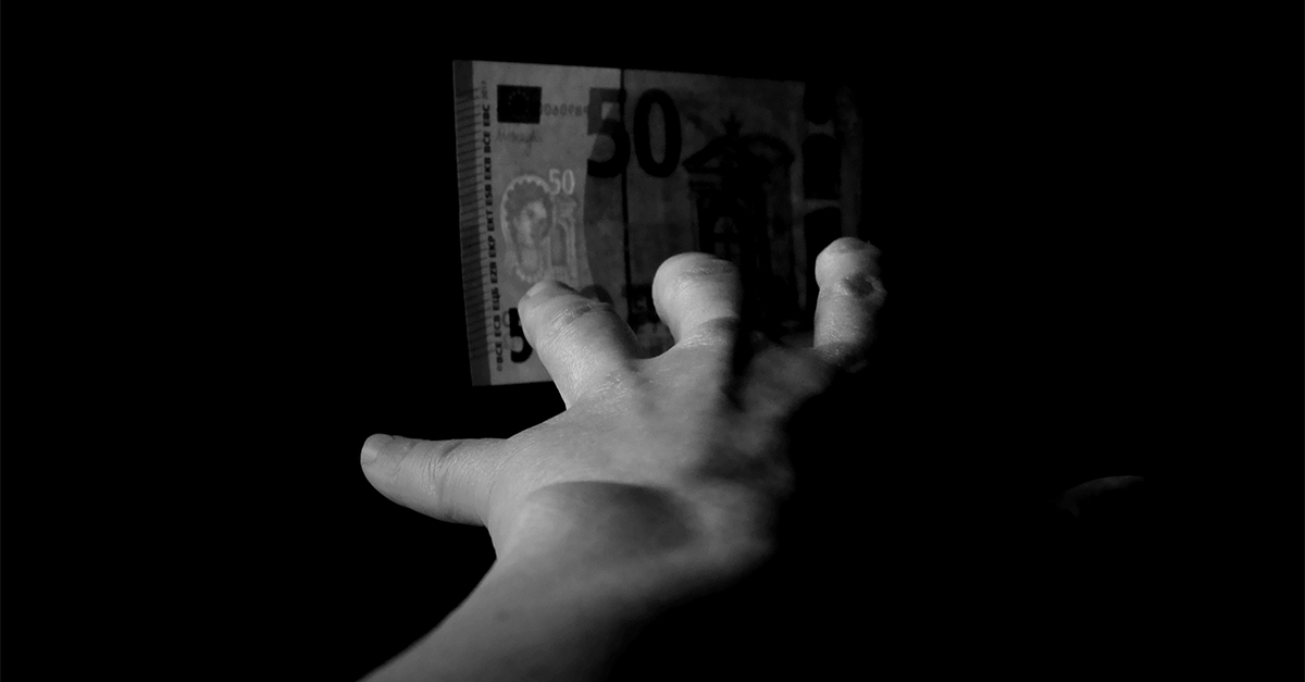 man reaching toward money