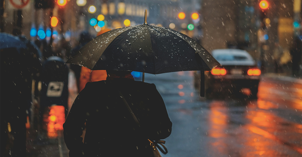 man walking in the city with umbrella in the rain