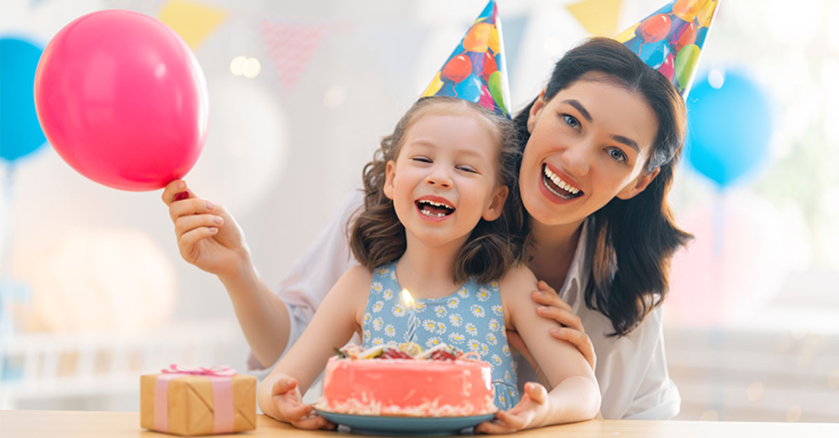 Woman and kid blow out candles on the cake