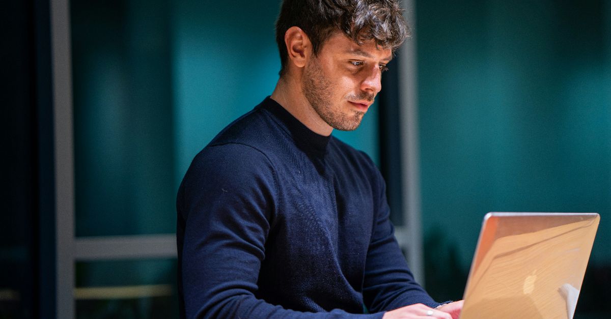 man in black long sleeve shirt using macbook