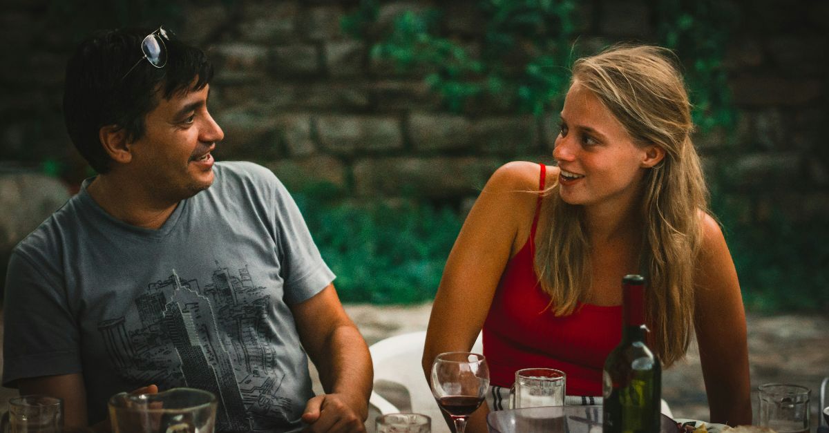a man and a woman sitting at a table with wine glasses