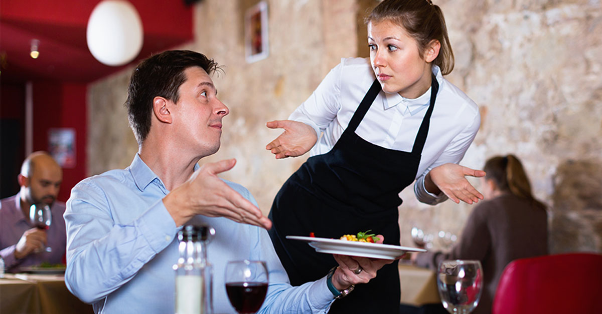 Angry unhappy man complaining to apologetic waitres