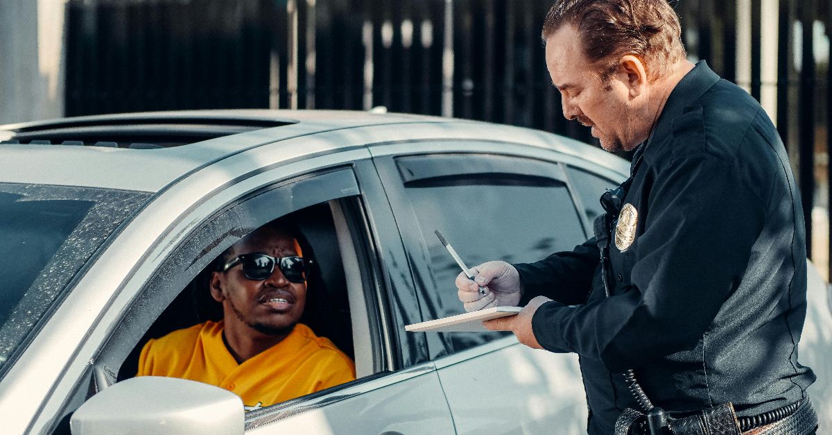 Police officer writes a traffic ticket for a driver during a routine stop.