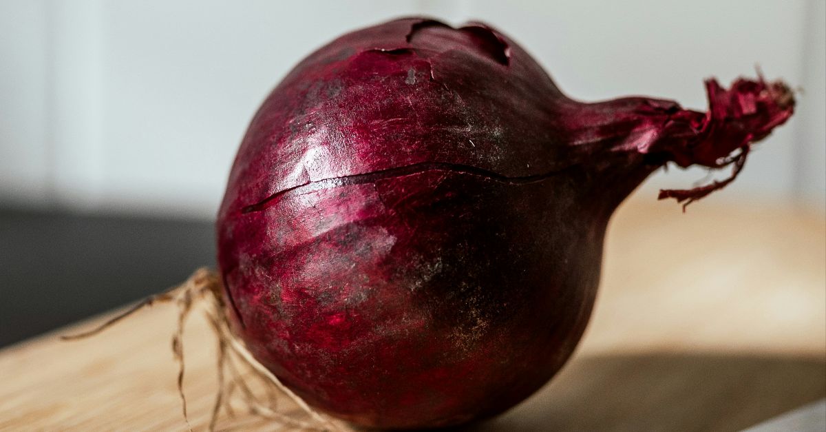 a red onion on a wooden surface
