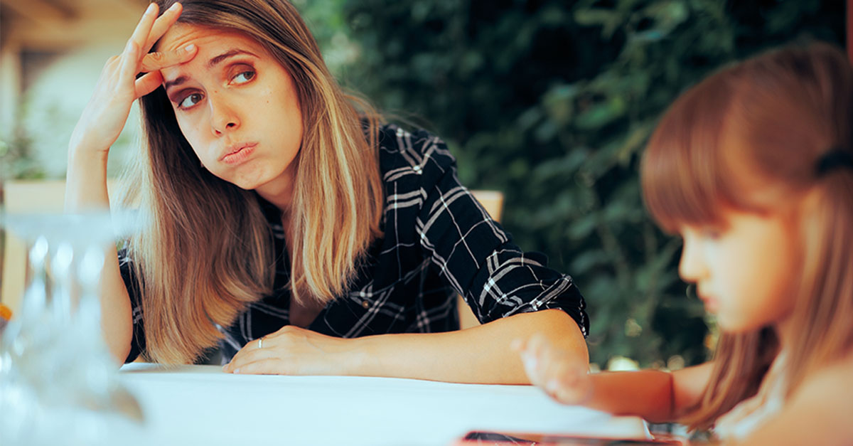 Tired Mother Sitting in a Restaurant Having a Headache