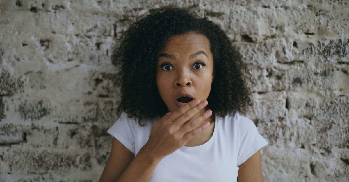 A surprised woman with hand over her mouth