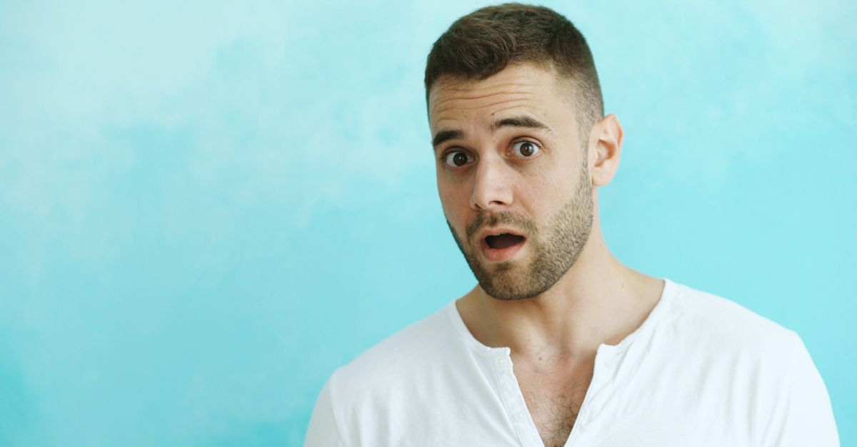 Man with surprised expression against blue background