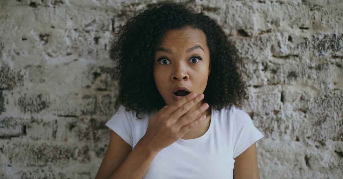 A surprised woman with hand over her mouth