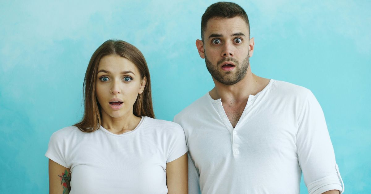 Couple with shocked expressions against blue background