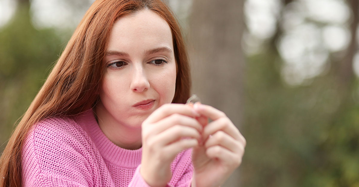 Red-haired woman looks at her engagement ring
